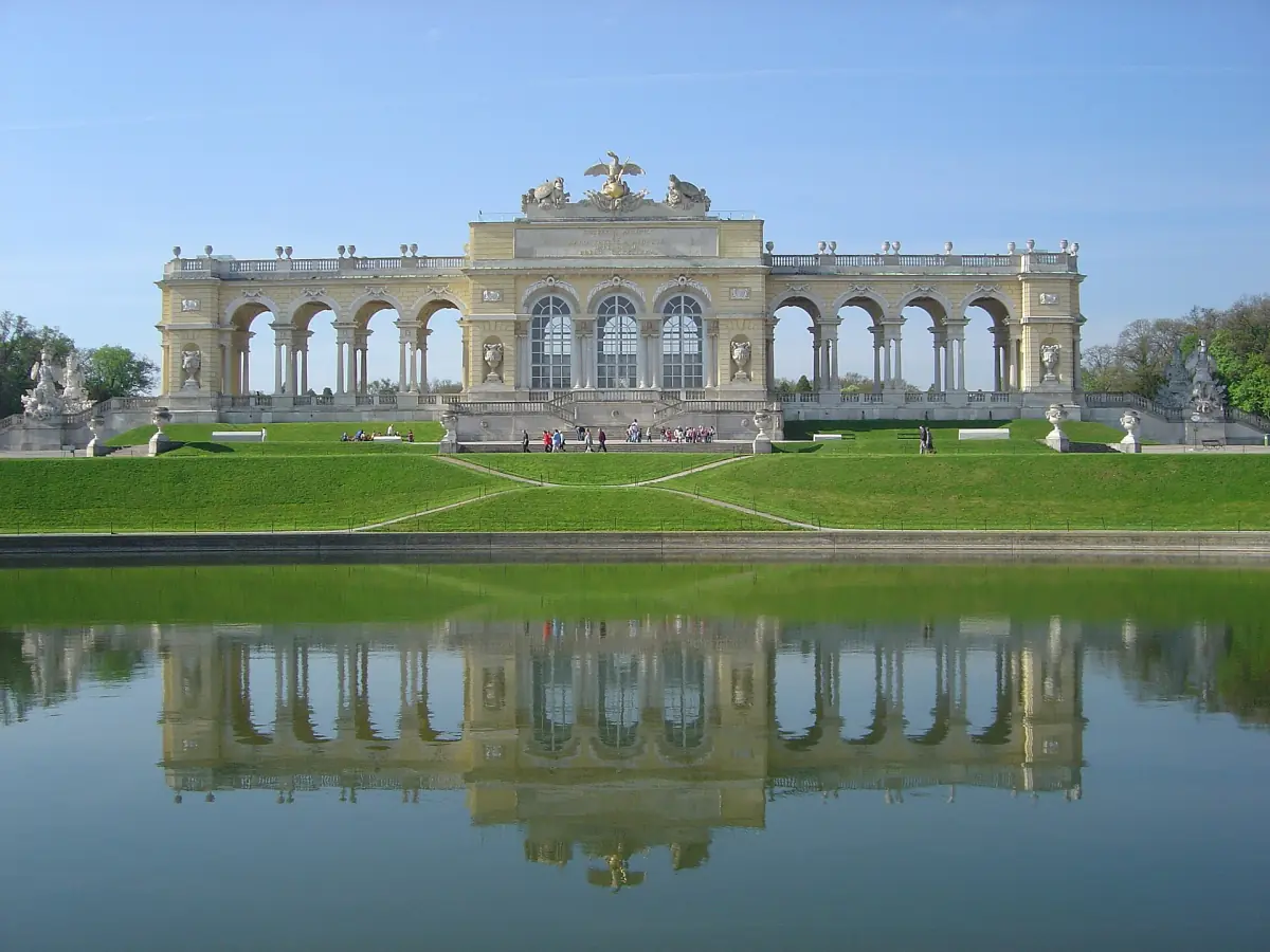 The Gloriette on its hill, reflected in the pond below